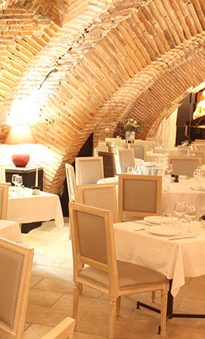 Vue intérieur du restaurant Les Caves de la Maréchale, avec une dizaine de tables dressées